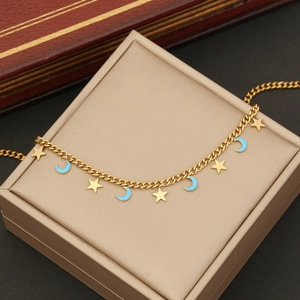 Detailed close-up of gold chain necklace with star and blue enamel moon charms