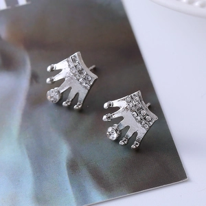 Macro shot of silver crown stud earrings with sparkling white crystals and elegant details