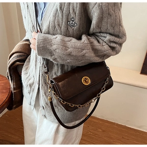 Detail of vintage brown soft leather bag with gold clasp and chunky metal chain strap