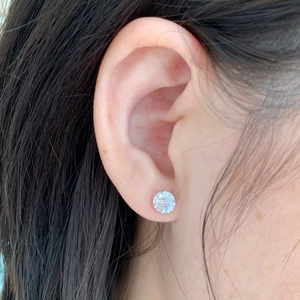 Close-up of S925 sterling silver stud earring with clear round zircon on female model