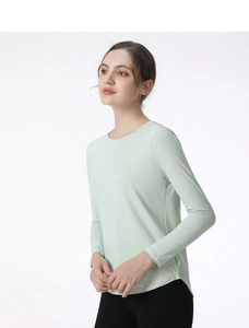 Detail of light green sports top featuring curved hem and breathable side mesh panels