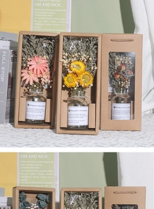Close-up of dried flower arrangements in glass bottles inside brown paper gift boxes