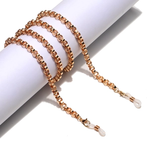 Golden metal eyewear chain with adjustable silicone loops shown on a white roll