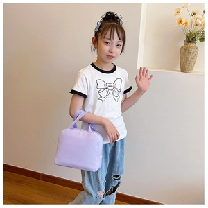 Young girl modeling a light purple insulated lunch bag with casual outfit in natural setting