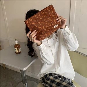 Détail de la trousse de toilette en velours côtelé caramel avec imprimés marguerites