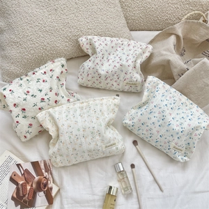 Macro detail of four floral lace cosmetic bags with different patterns in a soft setting