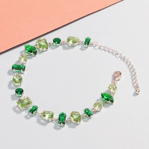 Detail of silver bracelet with varied green cubic zirconia in pear and oval shapes