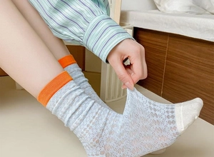 Close-up of light blue mesh sock showing elastic stretch and breathable knit fabric
