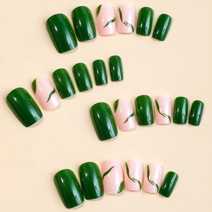 Green and pink press-on nails with abstract striped patterns on a beige background