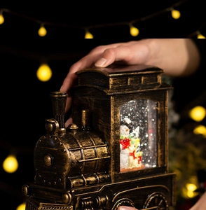 Handheld vintage bronze Christmas train lantern with glowing snowman and glitter snow detail