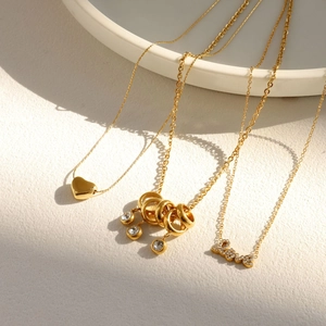 Trois colliers élégants en acier inoxydable doré 18 carats avec pendentifs cœur et Love