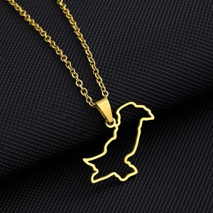 Detailed close-up of a gold-plated Pakistan map hollow pendant on a black textured surface