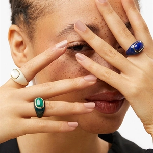 Macro detail of 18k gold plated rings with malachite, mother of pearl and blue enamel