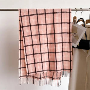 Detail of pink plaid cashmere scarf showing soft texture and fringe tassels
