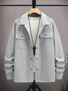 Detail of light gray corduroy jacket with chest pockets and vintage bolo necklace accessory