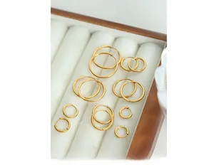 Detailed set of varied size gold plated stainless steel hoop earrings in a wooden box