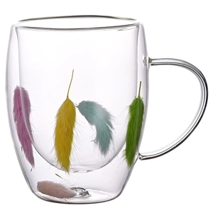 Double-wall borosilicate glass mug with colorful feathers inside and handle detail