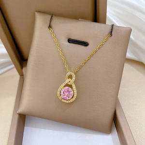 Macro view of gold-plated waterdrop necklace with pink gemstone and pavé diamonds