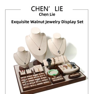 Macro view of walnut wood jewelry display set with beige velvet neck busts and trays