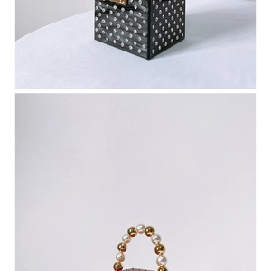 Close-up of black acrylic evening bag featuring silver rhinestones and pearl handle detail