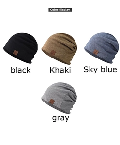 Close-up of four ribbed knit beanies in black, khaki, blue, and gray with leather patches