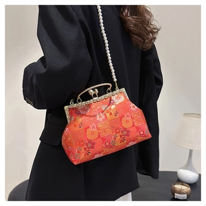 Detail of red embroidered floral bag with pearl chain and vintage metal clasp