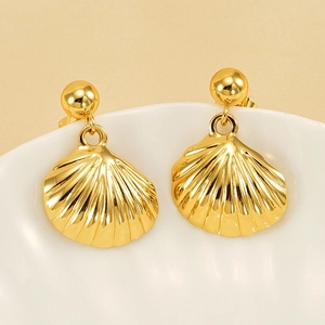 Elegant gold shell stud earrings with vintage ocean style on white porcelain