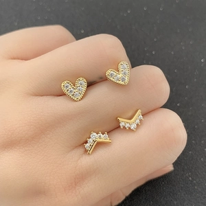 Macro shot of gold-plated heart and V-shape stud earrings with micro-inlaid cubic zirconia