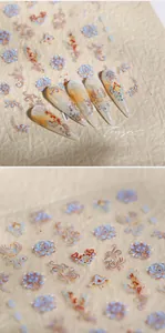 Macro detail of 3D embossed Phoenix and floral nail art stickers with gold accents