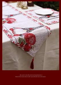 Detail of Christmas table runner with gnomes and red tassels on festive jacquard fabric