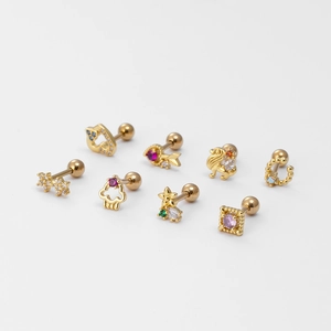Set of 7 gold heart flower ear studs with colorful cubic zirconia on white background
