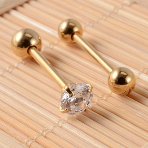Golden stainless steel tongue ring set with zircon inlay on a textured bamboo background