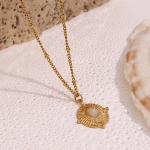 18K gold plated stainless steel necklace with white crystal pendant on a natural background
