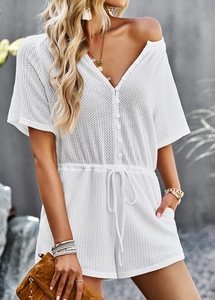 Detailed texture of white waffle knit romper featuring V-neck and drawstring waist