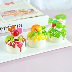 Detailed view of artificial fruit cakes in red, yellow, and green for home decoration