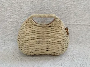 Detail of straw handbag with brown leather flap and golden metal clasp for summer