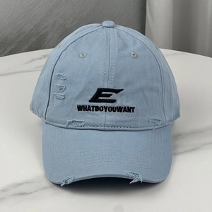 Detailed close-up of light blue distressed baseball cap with embroidered letter E logo
