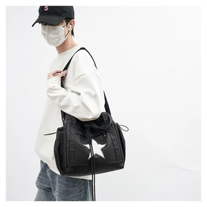 Side view of black star logo tote bag with drawstring details on a male model
