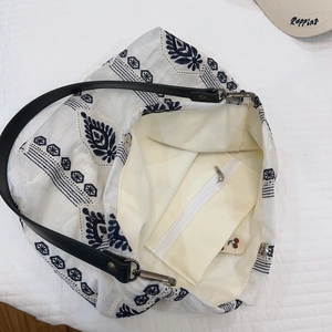 Detail view of cotton linen tote bag interior with embroidery and zipper pocket