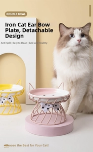 Detail of raised iron cat bowl stand with bow decoration and detachable ceramic dish