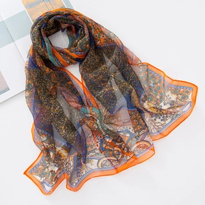 Detail of colorful georgette silk scarf featuring peacock and floral patterns on white background