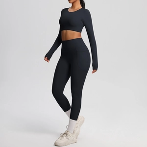 Detail of solid black long sleeve crop top and high waist leggings with side pockets