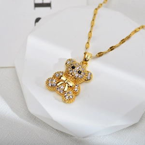 Macro detail of gold bear pendant with white zircon stones and black gemstone eyes