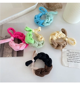 Close-up of five colorful braided high-elasticity hair ties in a flat lay aesthetic