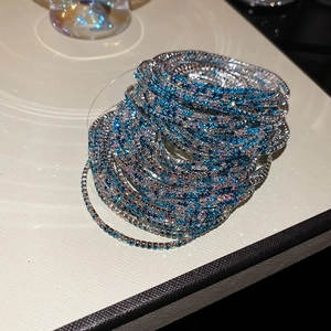 Macro shot of layered blue and white rhinestone bracelets with gradient crystal effect