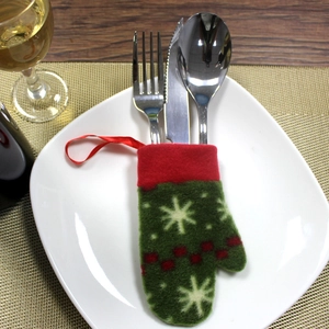 Close-up of a festive red and green Christmas glove-shaped cutlery holder on a plate