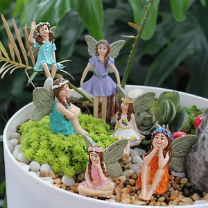 Macro detail of six resin flower fairy figurines in a miniature succulent garden pot