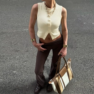 Photo street style d'un gilet en maille boutonné beige et d'un pantalon marron