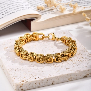 Macro view of gold stainless steel Byzantine twisted chain bracelet with lobster clasp detail