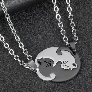 Macro shot of silver and black cat couple necklaces in Tai Chi style on dark surface
